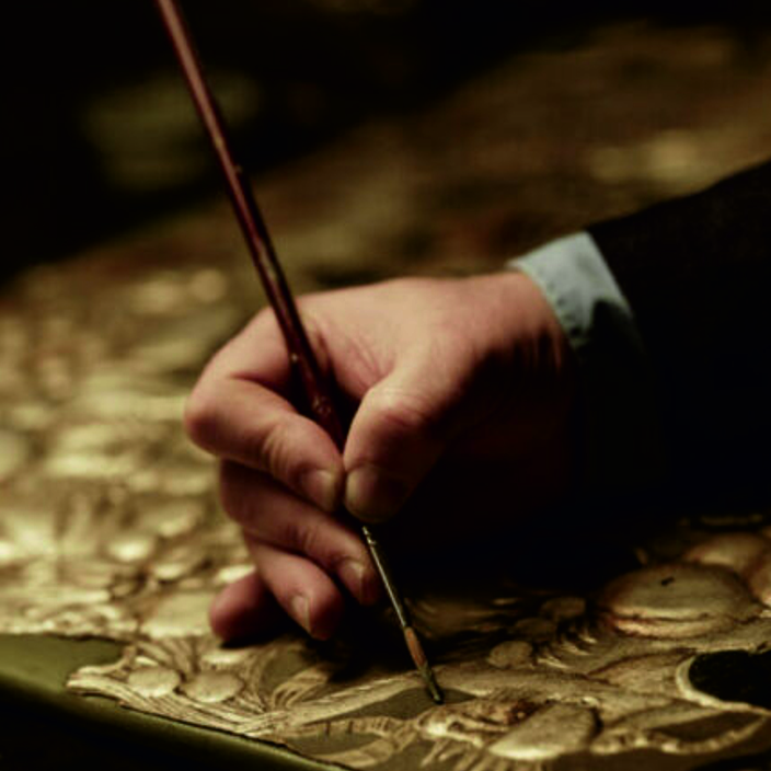 Ambachtsman beschildert goudleer met de hand - wat is goudleer